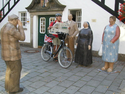 Rolf Harms mit Rad und der Dithmarscher Landeszeitung an den Skulpturen. Der Fotograf links ist übrigns nicht echt
